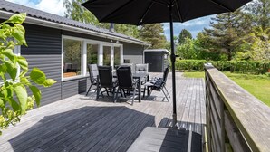 A deck with a table and chairs, an umbrella, and a wooden fence. - "Francis" - 300m from the sea by Interhome (Rødvig Stevns)