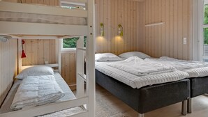 A bedroom with a bunk bed, a double bed, and a window with a view of greenery. - "Akkar" - 1.8km from the sea by Interhome (Blåvand)