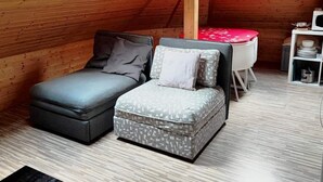 Quarto estilo loft com cama em mezanino, uma mesinha e micro-ondas.