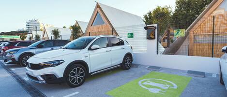 A parking area with electric vehicle charging stations, marked by green floor decals.
