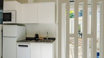 A modern kitchen with white cabinetry, a built-in microwave, a dishwasher, and a sink.