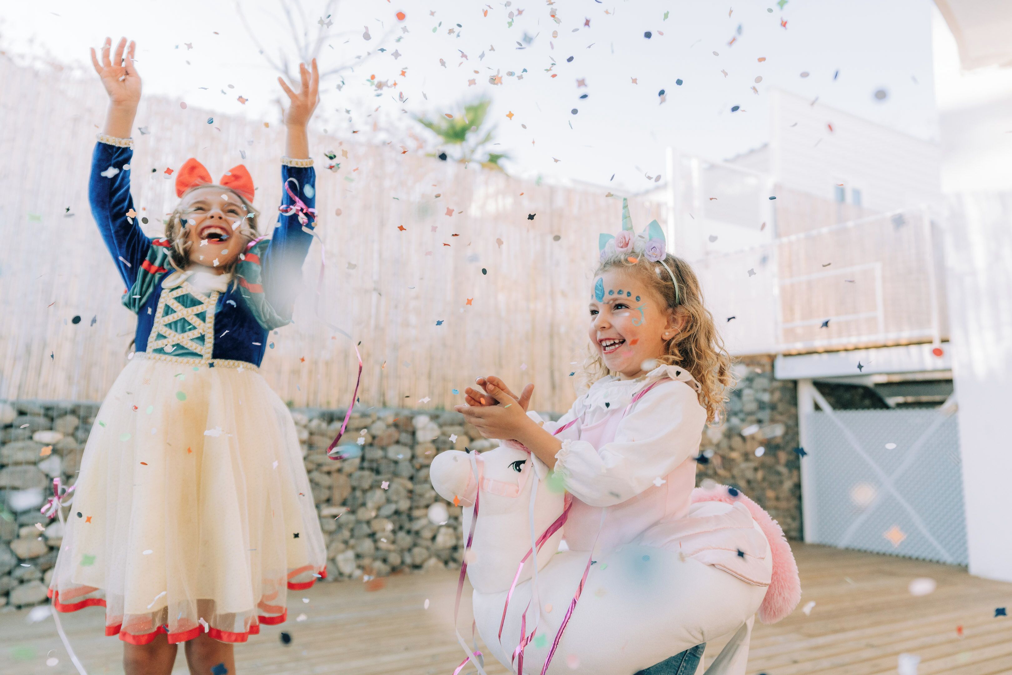 Deux enfants jouent avec des confettis.