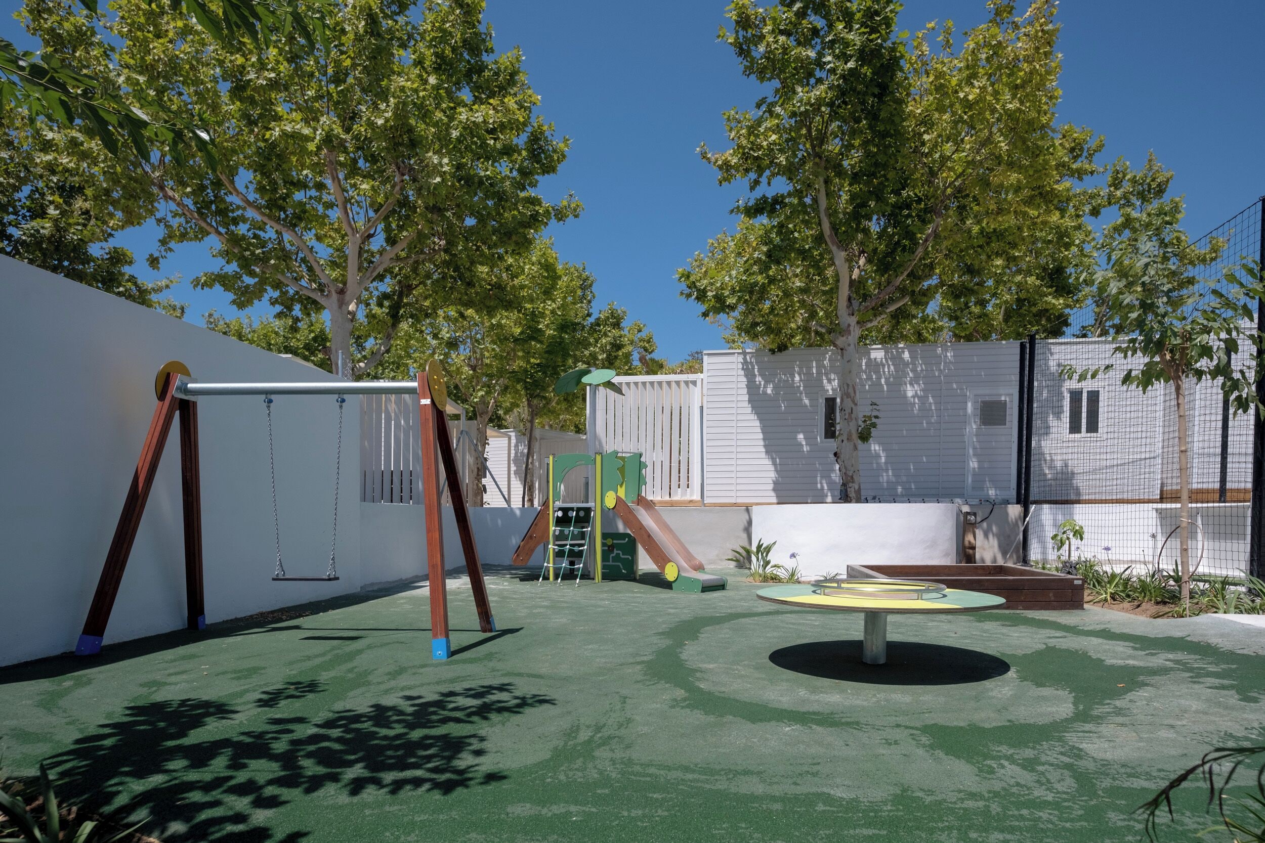 Un parque infantil con columpios, toboganes y una estructura para escalar.