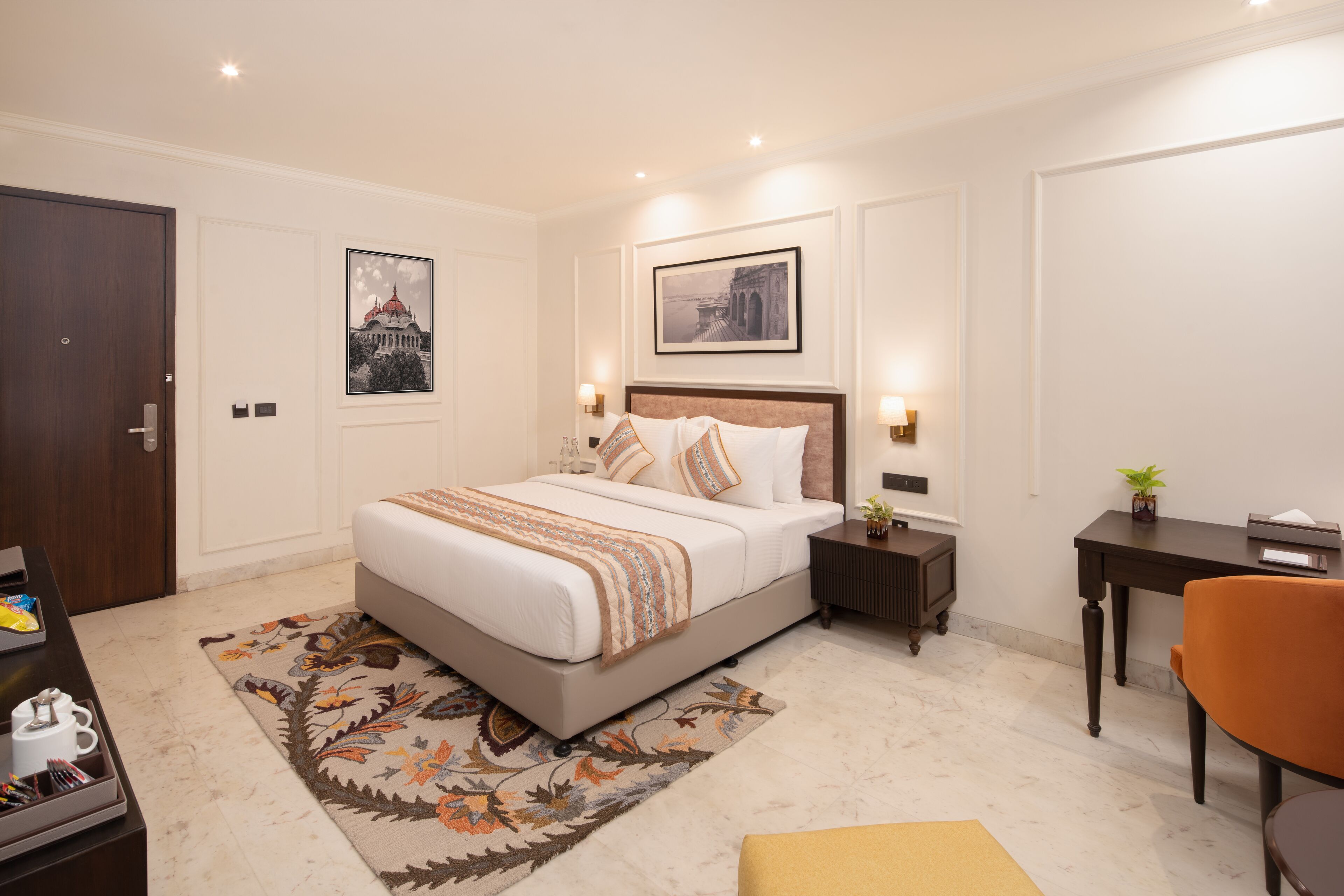 A modern bedroom with a large bed, bedside tables, a desk, and a chair.