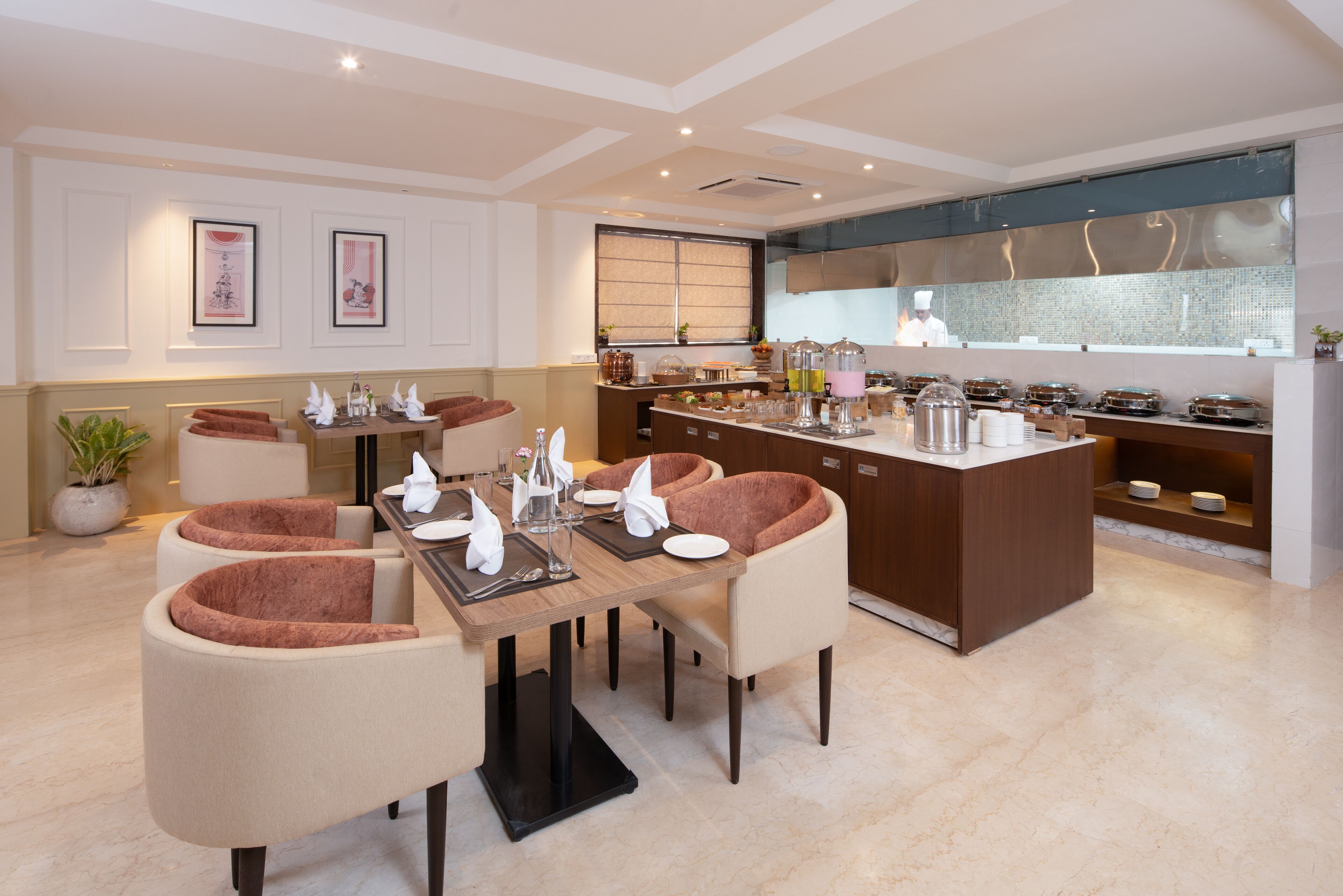 A modern dining area with a central island, cushioned chairs, and a kitchen in the background.