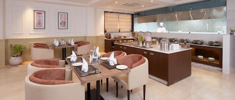 A modern dining area with a central island, cushioned chairs, and a kitchen in the background.