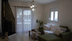 A living room with a fireplace, a sofa, a coffee table, and a window with curtains.