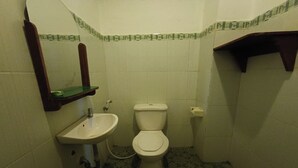 Ein kleines Badezimmer mit Toilette, Waschbecken und Spiegel.