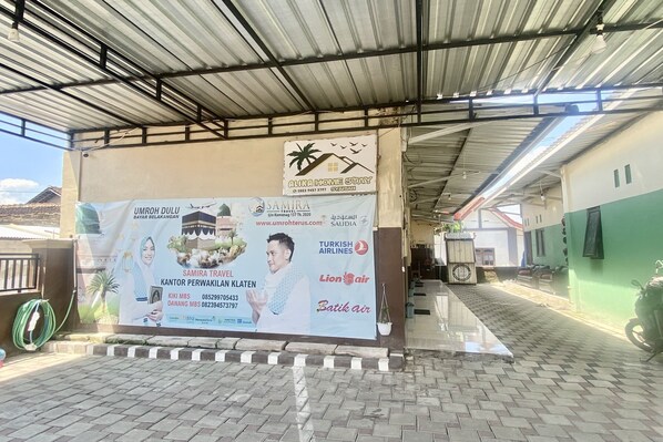 A covered outdoor area with a banner advertising Samira Travel and Turkish Airlines. - Capital O 93829 Alika Homestay Syariah (Klaten)