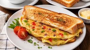 Ein Frühstückstisch mit Toast, Marmelade, Butter und einer Kaffeetasse.