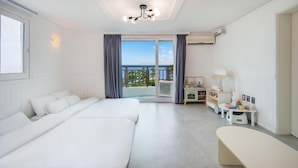 A hotel room with two beds, a balcony with a view, a kitchenette, and a vanity with a mirror. - Jeju Hi Mom Kids Family Pension Silver (Jeju City)