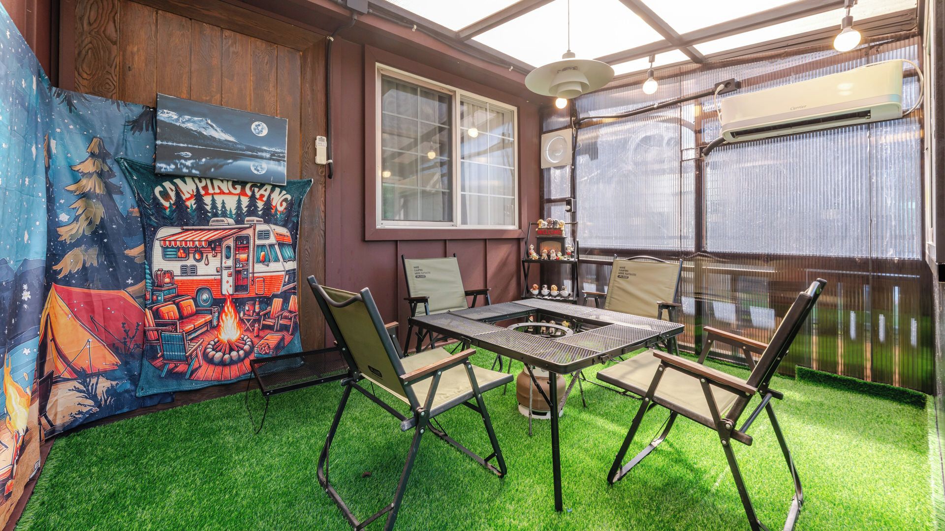 Un espace patio avec une table et des chaises, un tableau accroché au mur et une fenêtre.