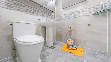 Un baño moderno con inodoro, lavabo y ducha.