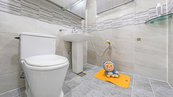 Un baño moderno con inodoro, lavabo y ducha.