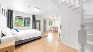 Une chambre moderne comprenant un lit, un bureau et un coin repas.