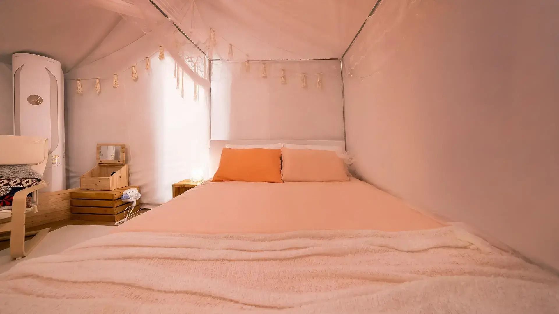 A bedroom with a bed, a nightstand, a chair, and a window.