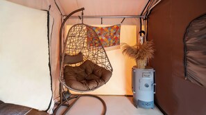 Ein gemütliches Interieur mit einem Hängesessel, Wanddeko und einem Heizgerät.