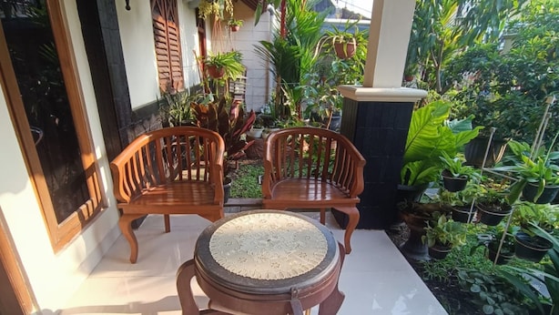 A patio with two wooden chairs and a round table with a patterned tabletop. - Hotel O Lies Kostel Syariah (Kendal)