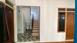 A hallway with a staircase leading to a room marked with the number 30. - Hotel O Lies Kostel Syariah (Kendal)
