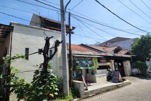 A building with a tiled roof and a signboard advertising a restaurant. - Hotel O Regina Homestay Syariah (Surabaya)