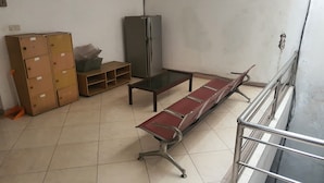 A waiting area with a bench, a refrigerator, and storage boxes. - Hotel O Regina Homestay Syariah (Surabaya)