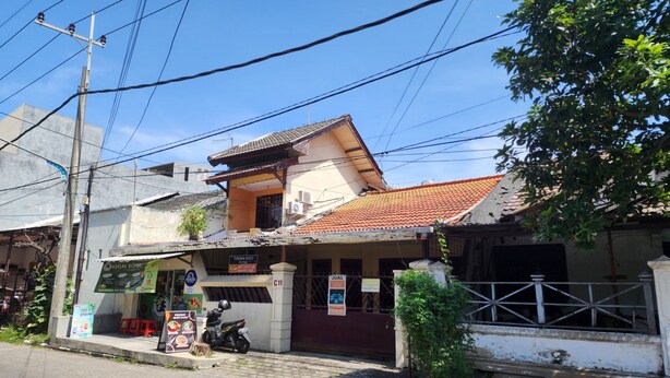 A two-story building with a tiled roof, a signboard for 'Kedai Soniq', and a motorcycle parked in front. - Hotel O Regina Homestay Syariah (Surabaya)