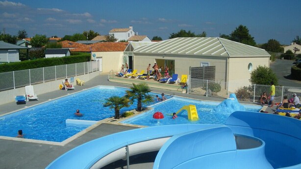 A swimming pool with slides and a covered area with lounge chairs. - Mobil Home 40 Grand Confort (Brem-sur-Mer)