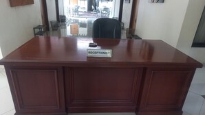 A reception desk with a nameplate reading "RECEPTIONIST" in a hotel lobby.