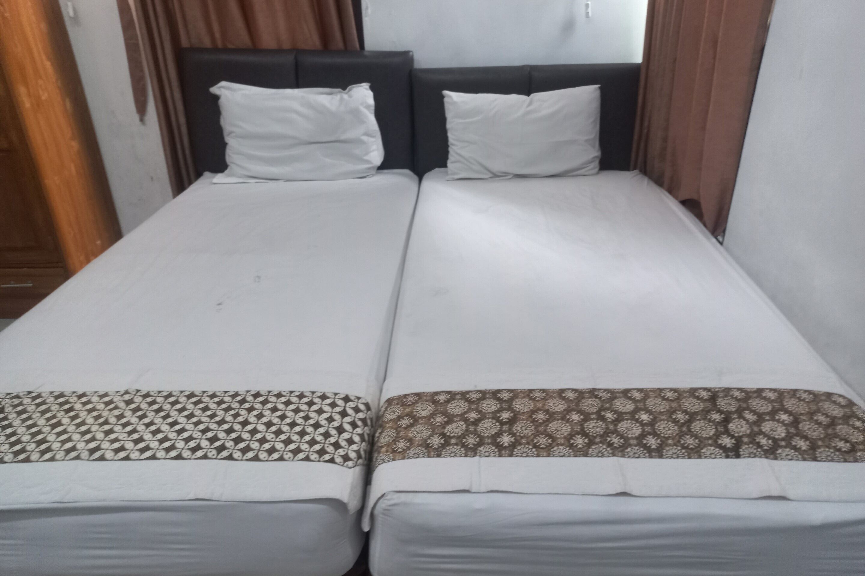 Un lit double avec une couvre-lit à motifs et deux oreillers.