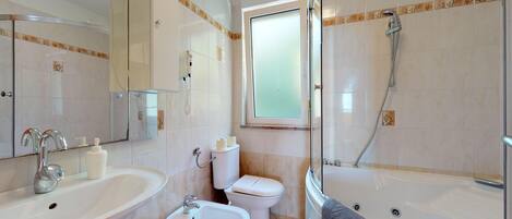 A modern bathroom with a sink, bidet, toilet, and a walk-in shower.