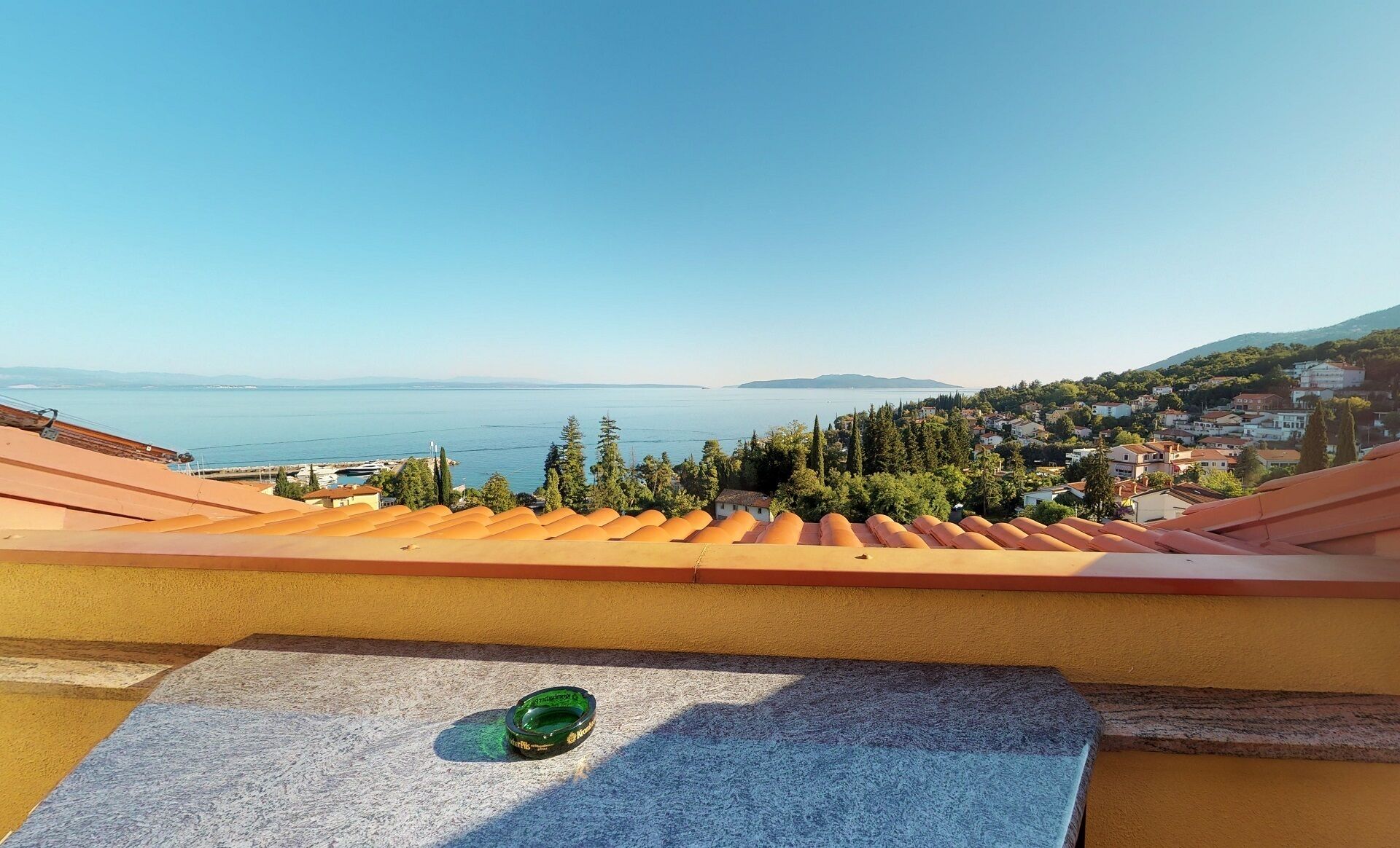 A terrace with a view of a coastal town and the sea.