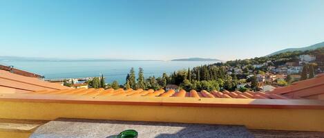 A terrace with a view of a coastal town and the sea.