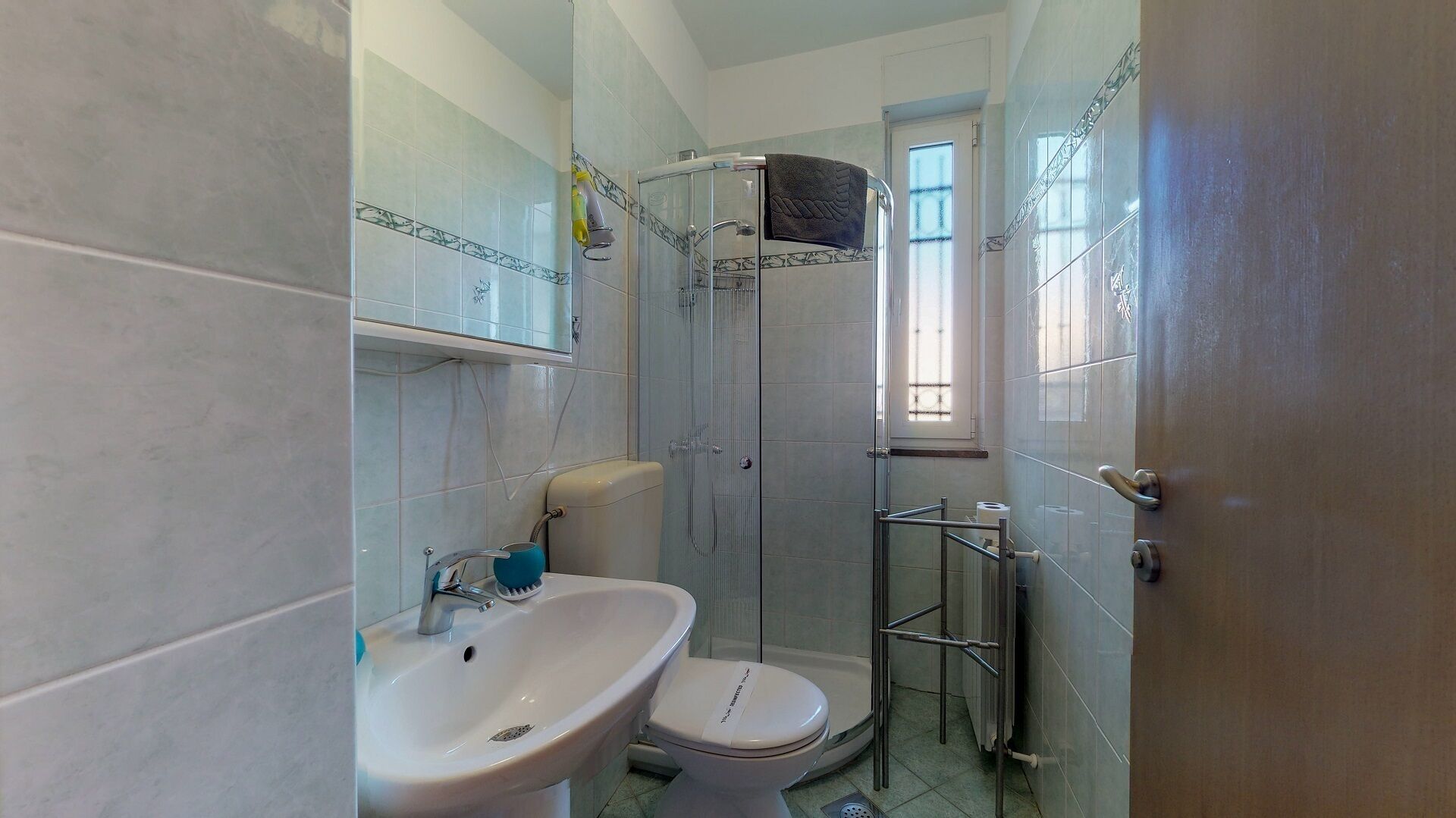 Une salle de bain avec douche, toilettes et lavabo.