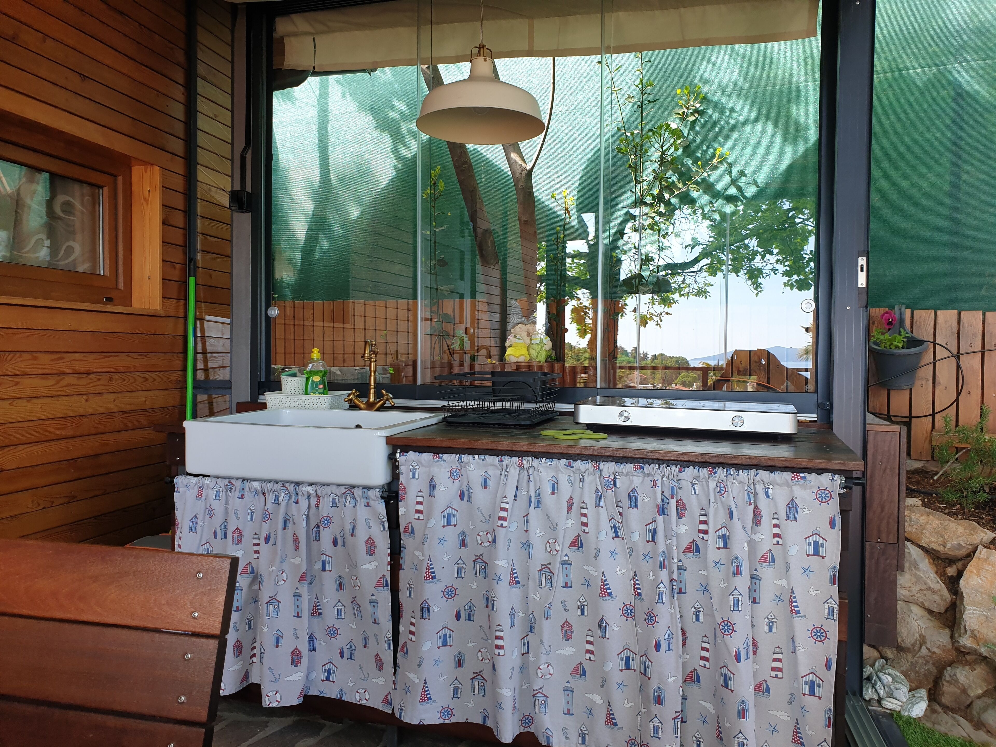 A kitchen with a window, a sink, and a table with a patterned tablecloth.