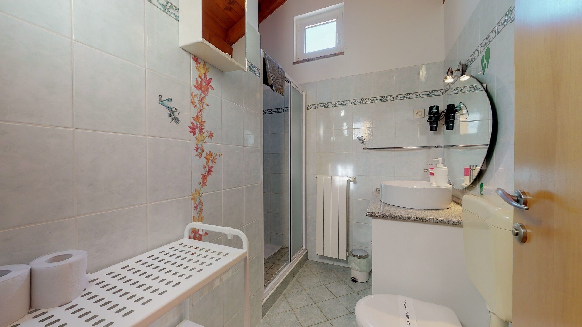 Ein Badezimmer mit Dusche, Toilette, Waschbecken und Handtuchhalter.
