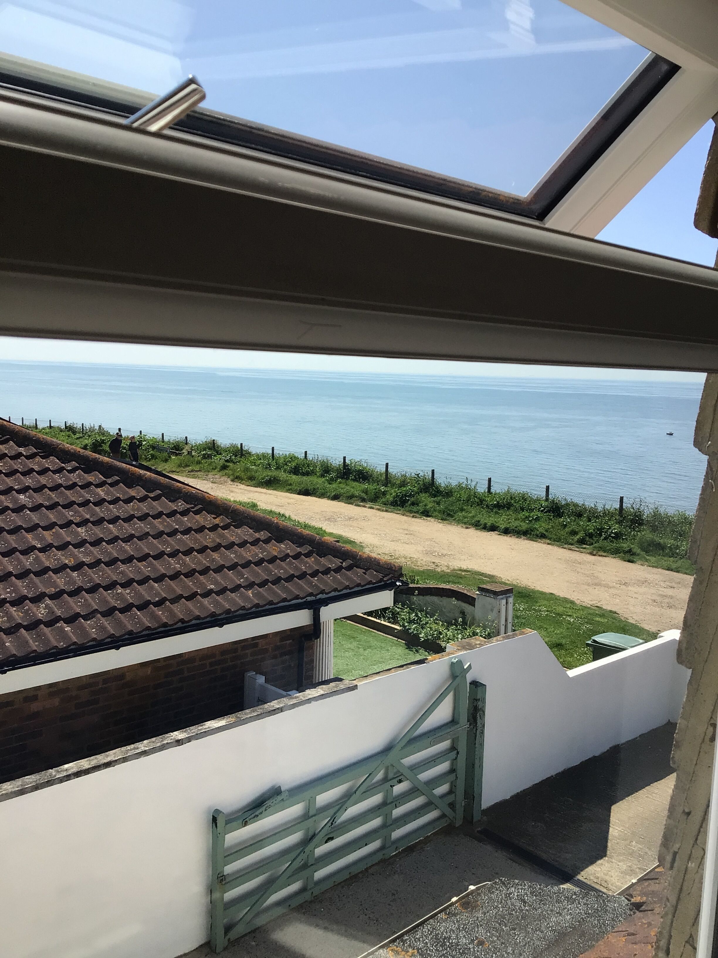 A view from a window overlooking a beach with a clear sky.