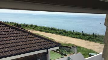 A view from a window overlooking a beach with a clear sky.