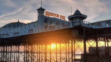 A pier with the sign "Brighton Pier" and a dome structure.