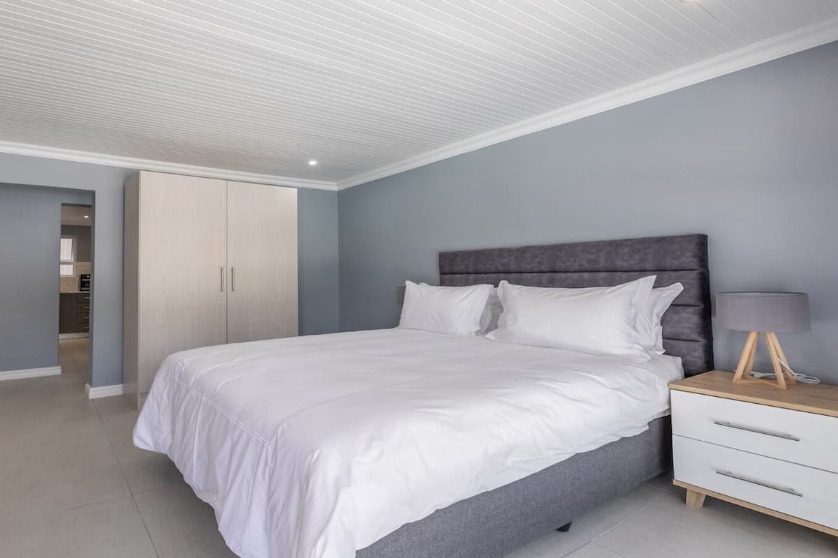 A bedroom with a bed, bedside table, and a wardrobe.