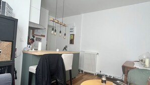 A modern, compact living space with a kitchenette, a dining area, and a seating area with a round table.