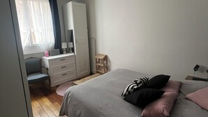 A bedroom with a bed, a dresser, a chair, and a desk.