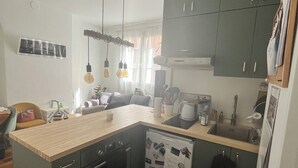 A compact kitchen with dark cabinets, a wooden countertop, and a built-in dishwasher.