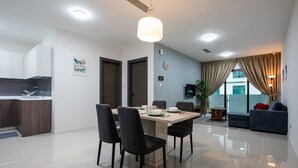 Una sala de estar moderna con una mesa de comedor, sillas, un sofá y un televisor.
