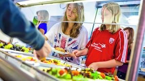 A buffet with various food items and a person serving food. - Jugendherberge Falkenberg (Falkenberg)