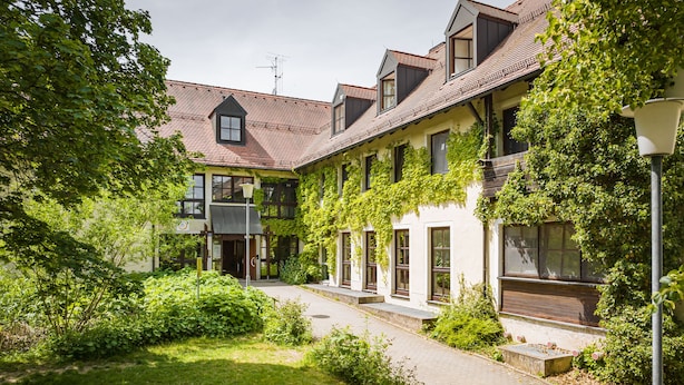 A traditional building with a tiled roof, multiple windows, and a well-maintained garden area. - Jugendherberge Falkenberg (Falkenberg)
