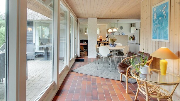 Una habitación amplia con ventanas grandes, un comedor y una cocina.
