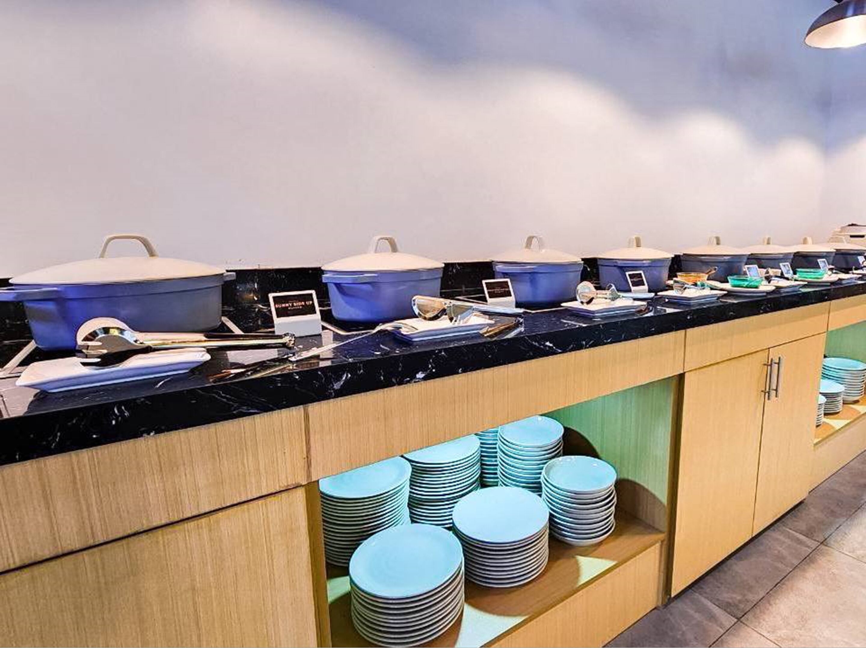 A buffet setup with multiple serving stations, including blue chafing dishes and a variety of food items.