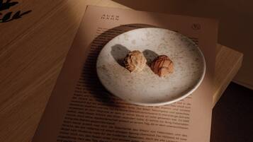 A plate with two desserts on a table, placed on a book.