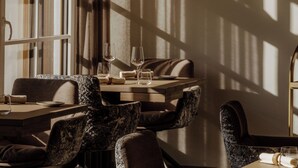 Een eetgedeelte met een tafel gedekt voor twee personen, uitgevoerd in modern design met een combinatie van gestreept en effen bekleding.