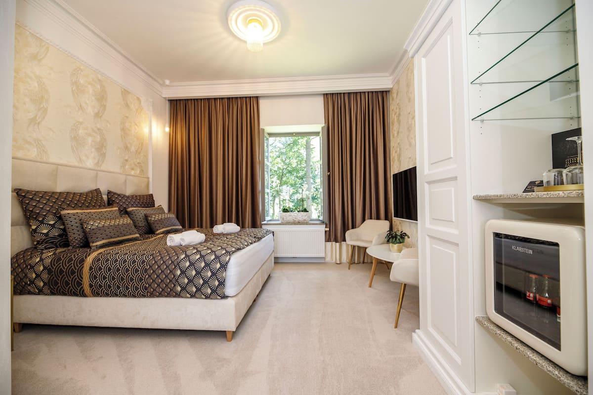 Een slaapkamer met een groot bed, een televisie en een open haard.